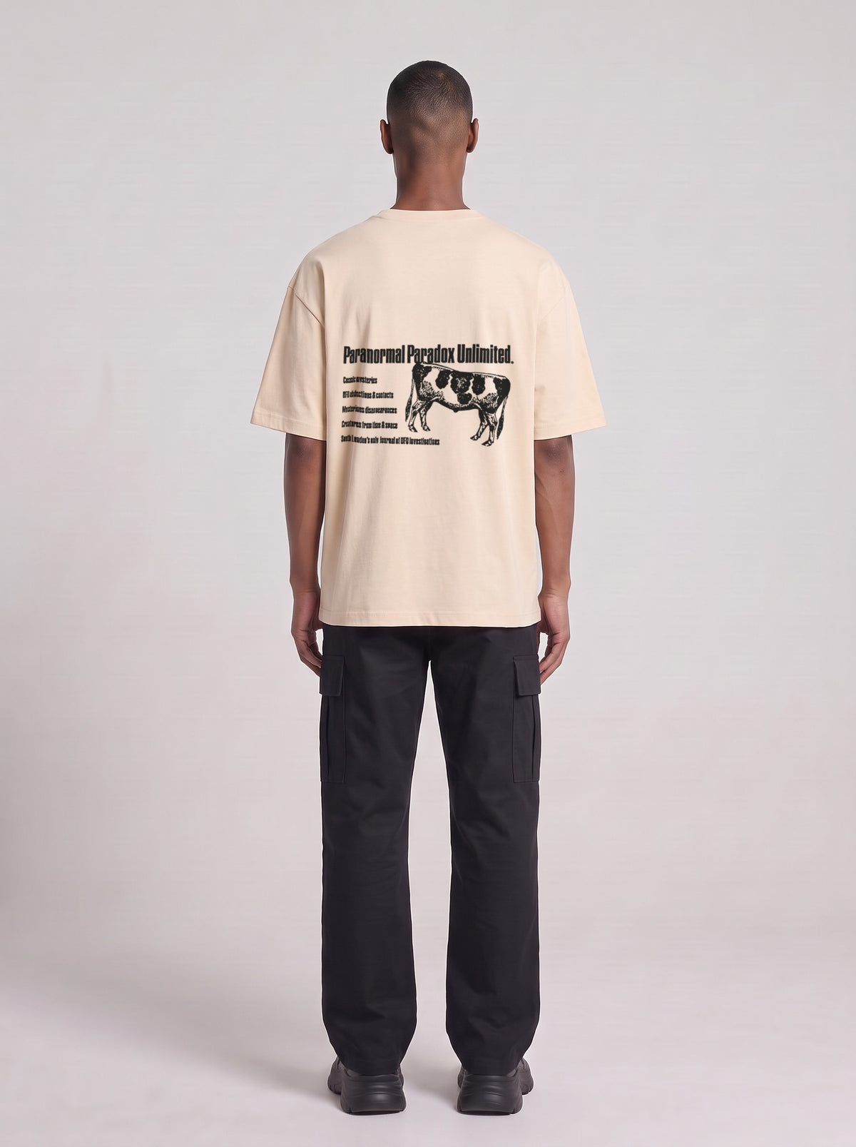 Paranormal Paradox — Drop Shoulder T-Shirt in Light Apricot, back, worn by male model