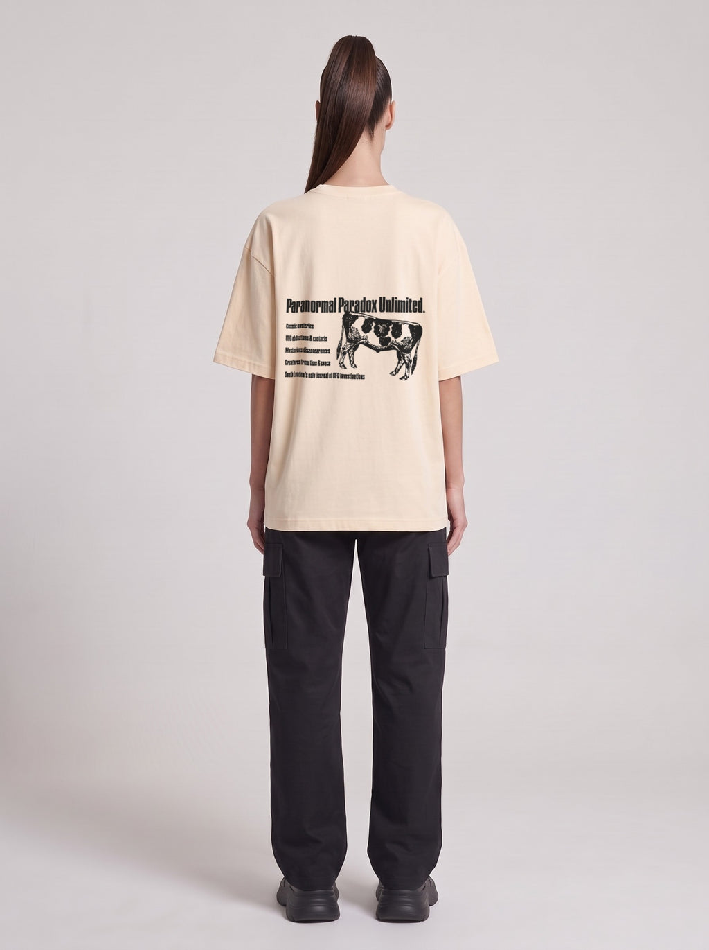 Paranormal Paradox — Drop Shoulder T-Shirt in Light Apricot, back, worn by female model