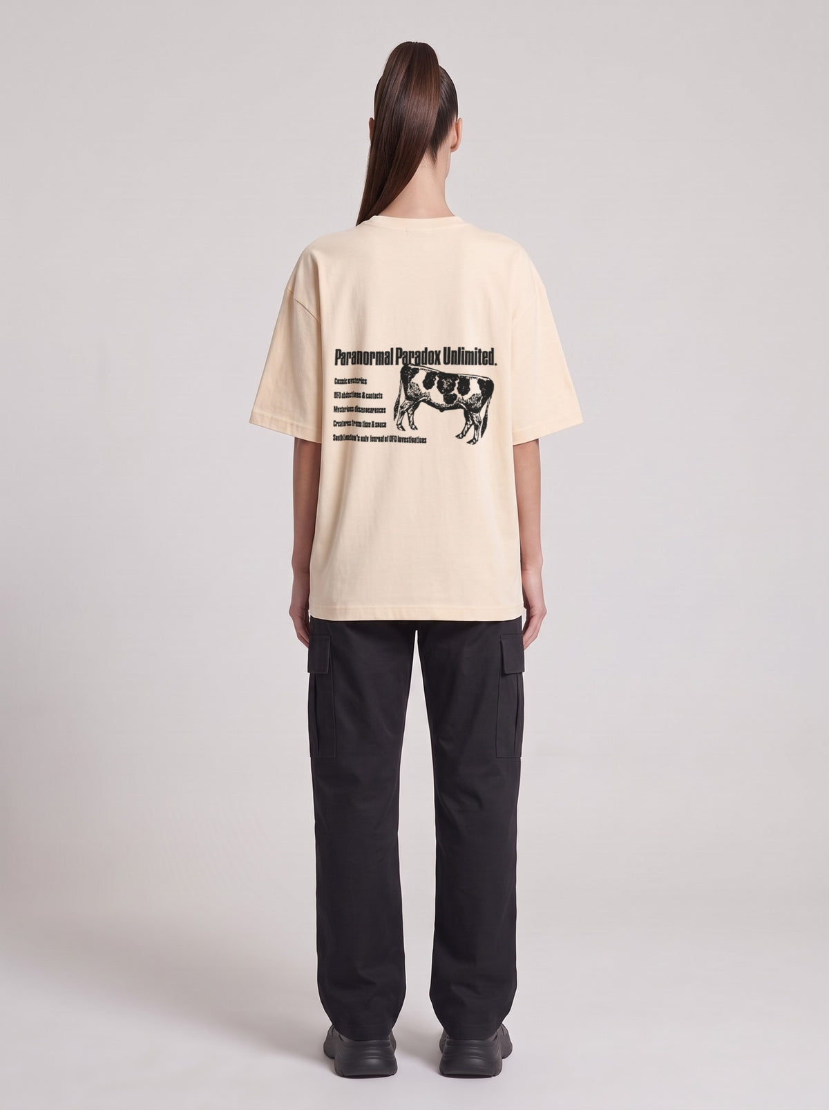 Paranormal Paradox — Drop Shoulder T-Shirt in Light Apricot, back, worn by female model