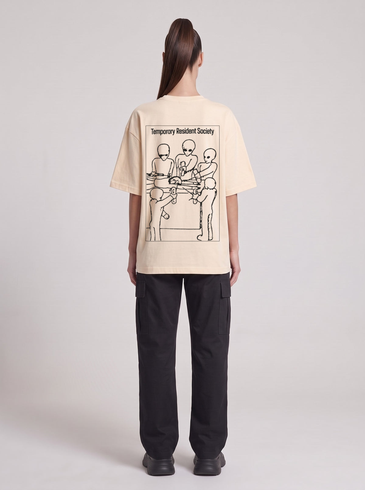 Temporary Resident Society — Drop Shoulder T-Shirt in Light Apricot, back, worn by female model